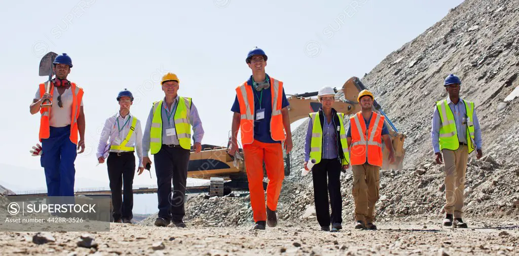 Workers and business people walking in quarry, Spain