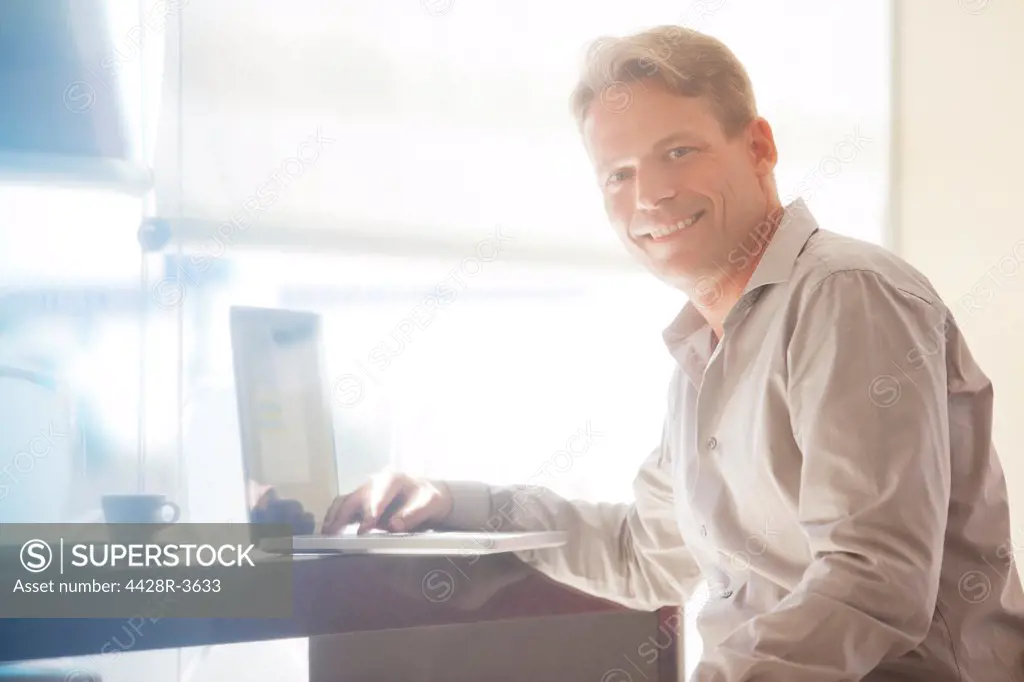 Businessman smiling at laptop, Spain