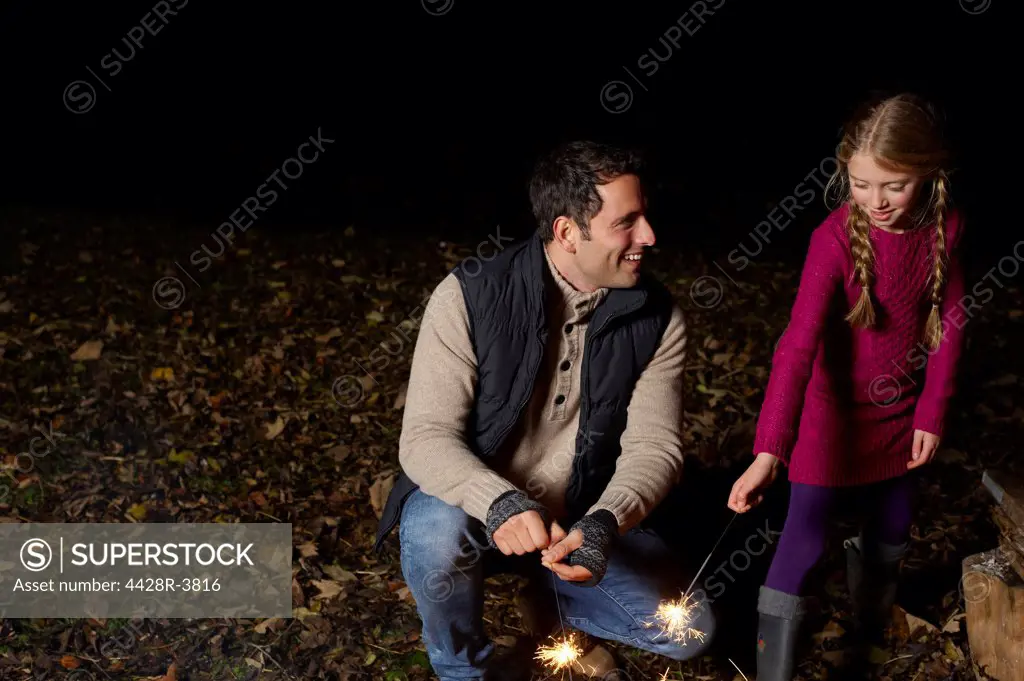 Father and daughter playing with sparklers,belmonthouse, UK