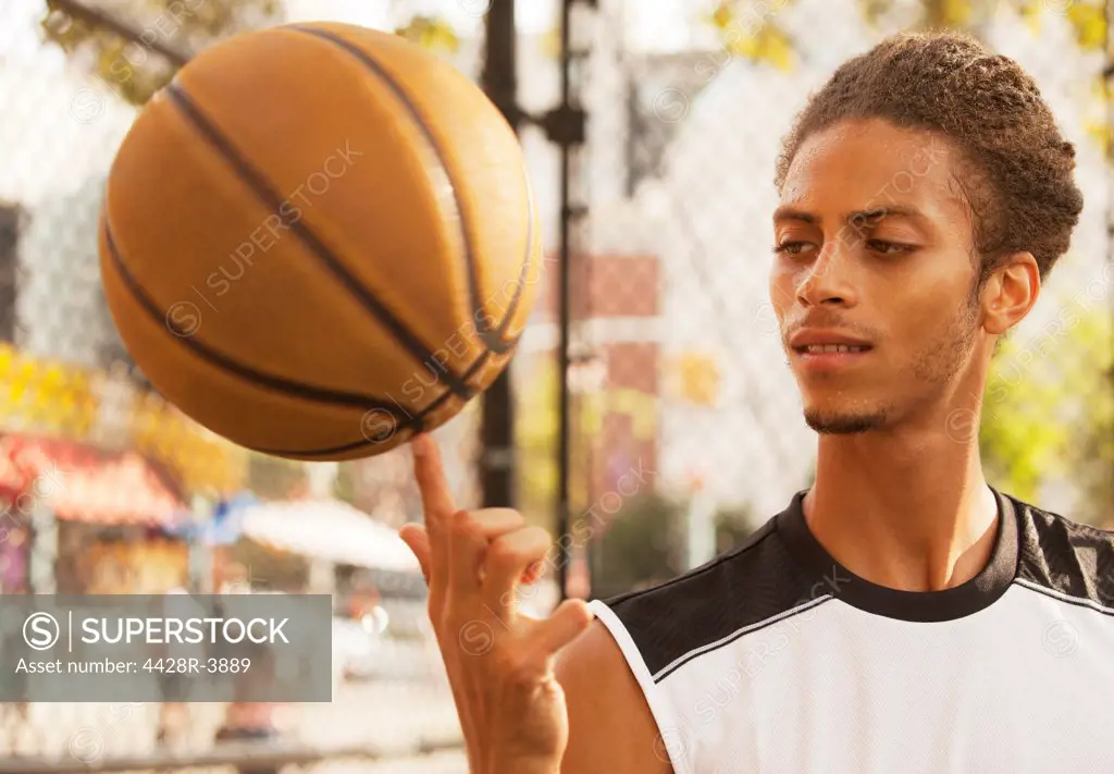 Man spinning basketball on finger,New York