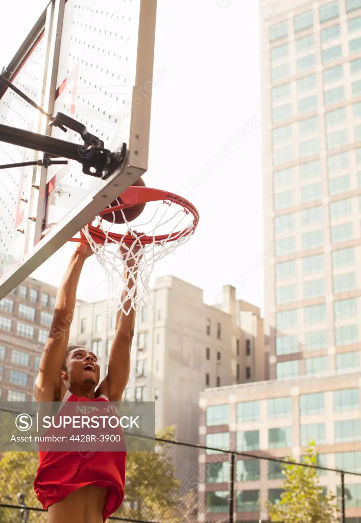 Man dunking basketball on court,New York