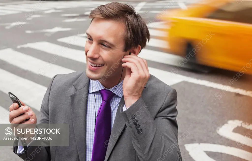 Businessman talking on cell phone on city street,New York