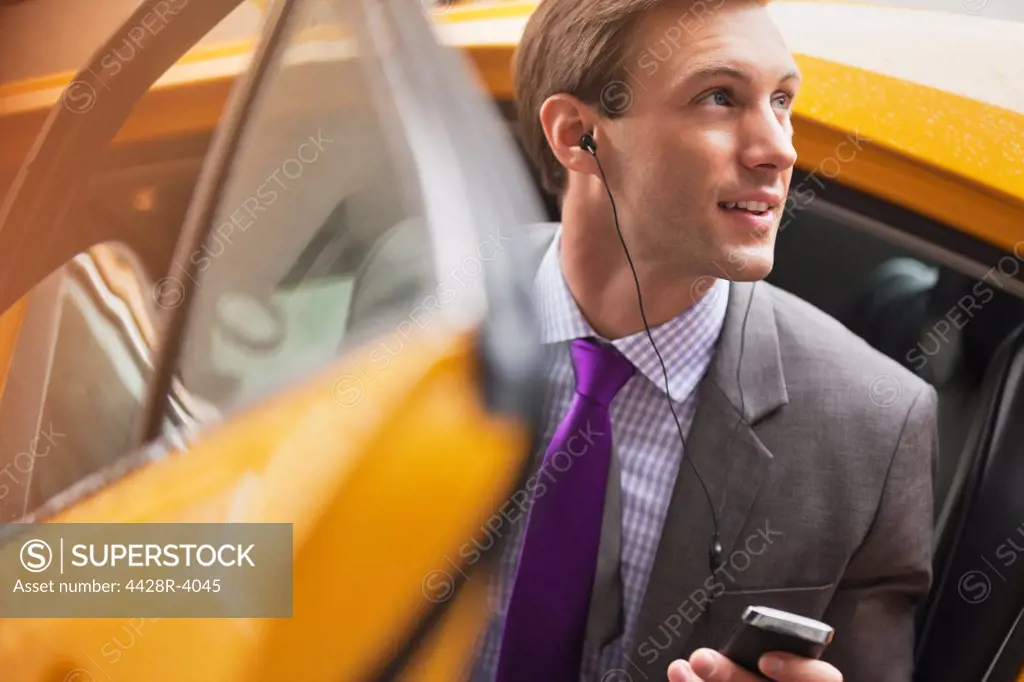 Businessman climbing out of taxi,New York