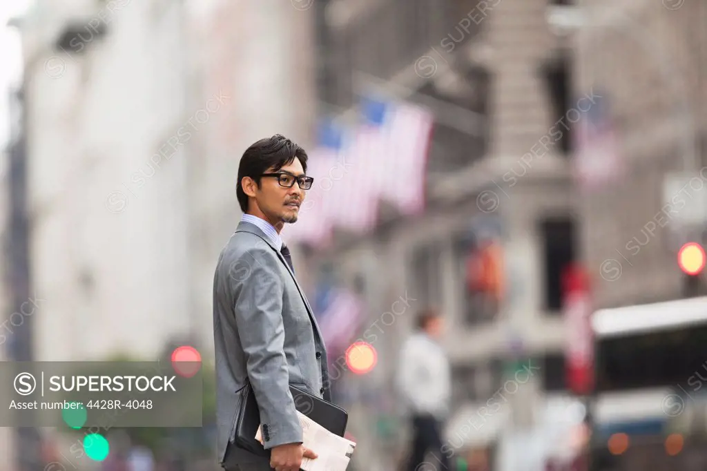Businessman standing on city street,New York