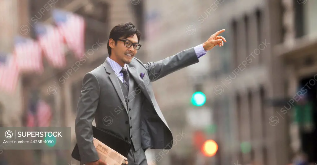 Businessman hailing taxi on city street,New York