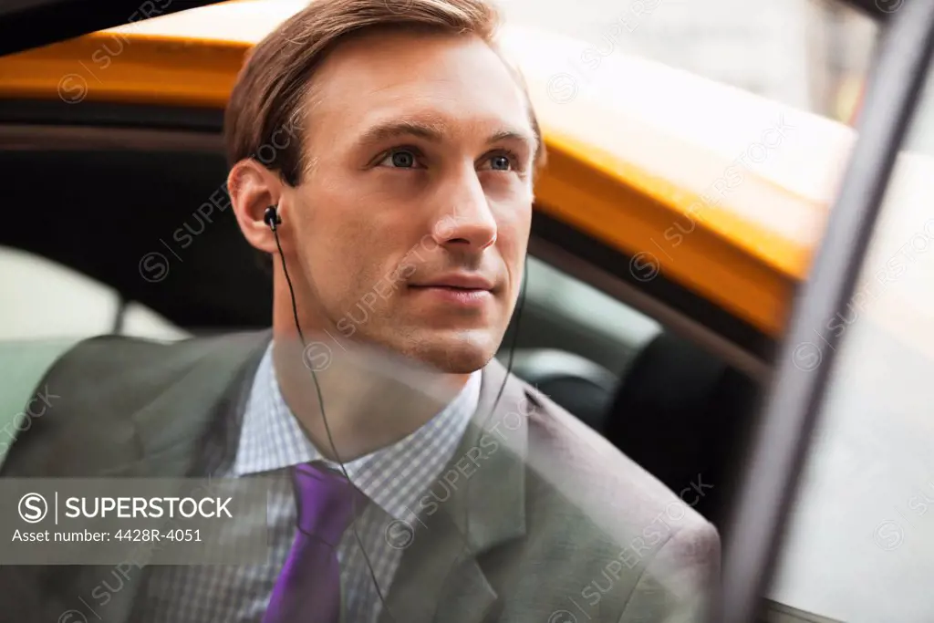 Businessman climbing out of taxi on city street,New York
