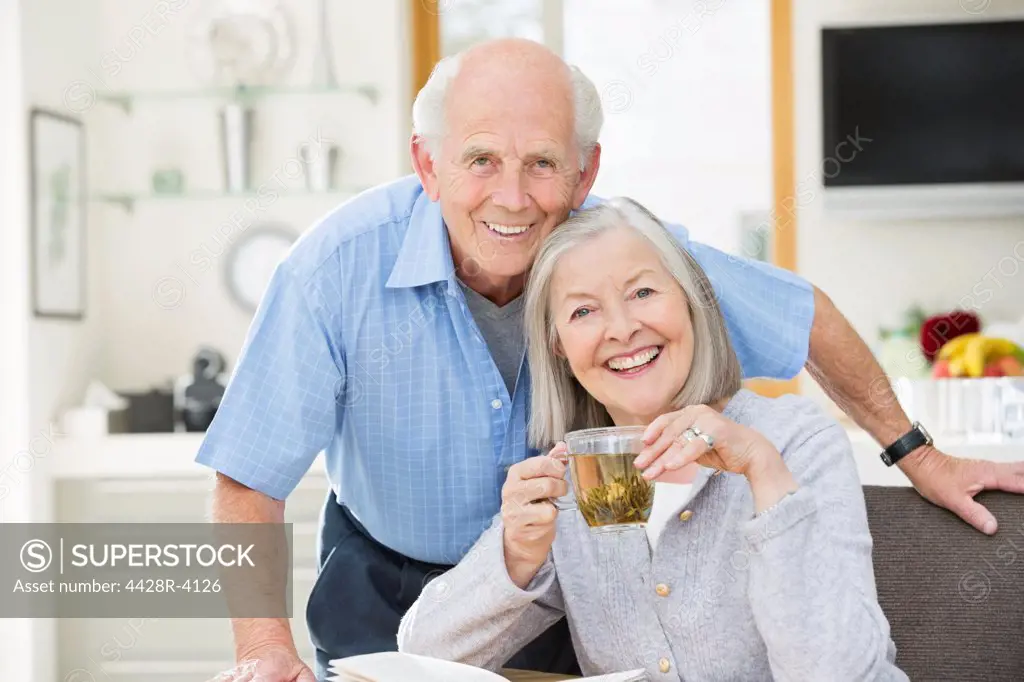 Older couple smiling in kitchen,East Grinstead, UK