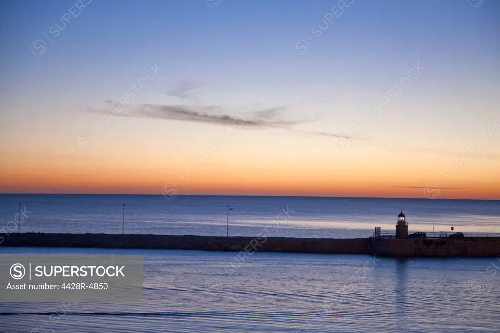 Sunrise sky over still ocean,Trani Harbour, puglia, italy