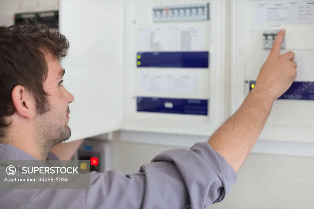 Electrician examining control panel