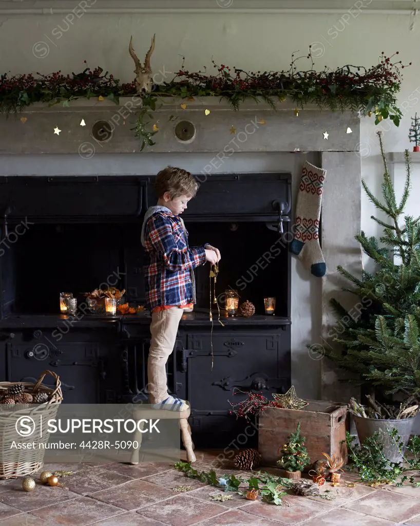 Boy decorating Christmas fireplace