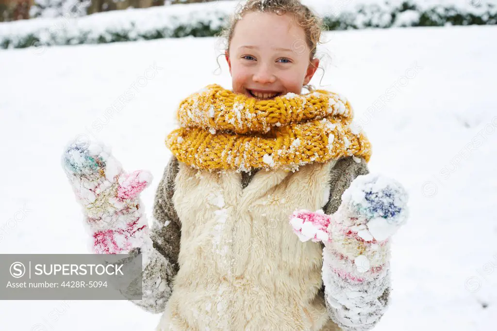 Smiling girl playing in snow