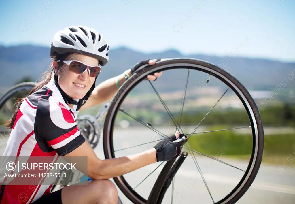 Cyclist adjusting tires on rural road