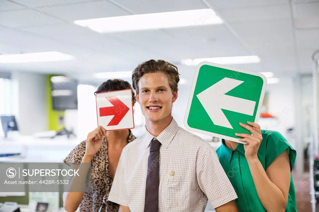 Business people holding arrows in office
