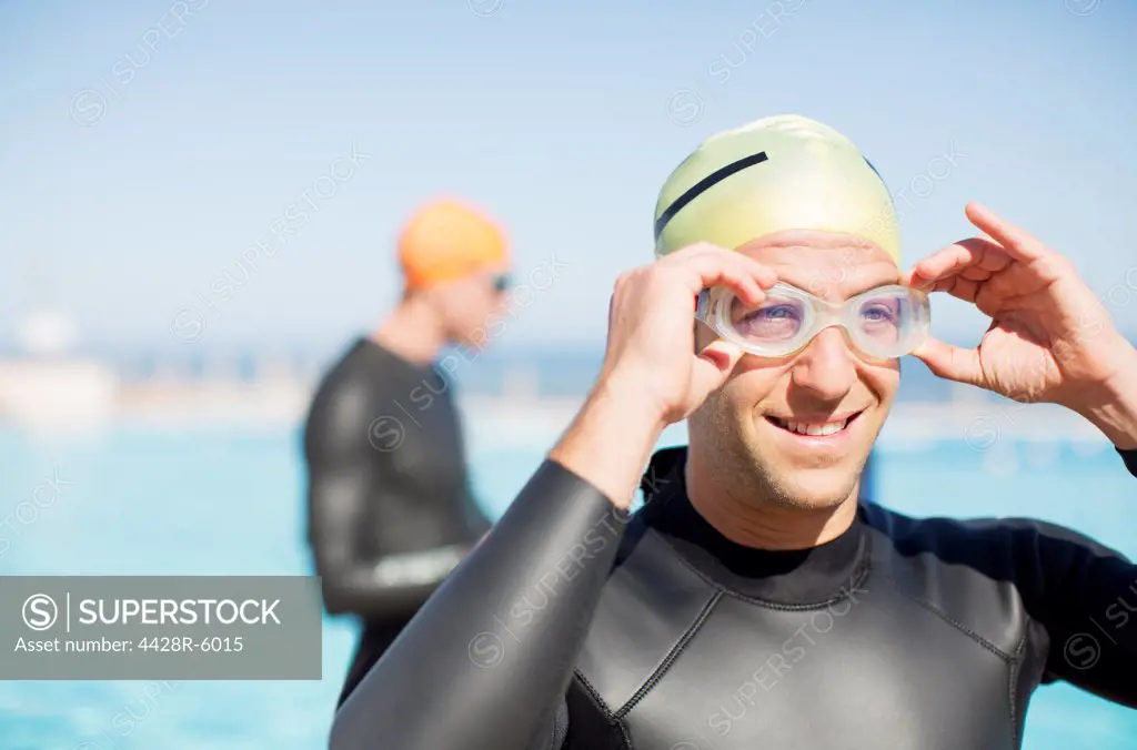 Triathlete adjusting goggles outdoors