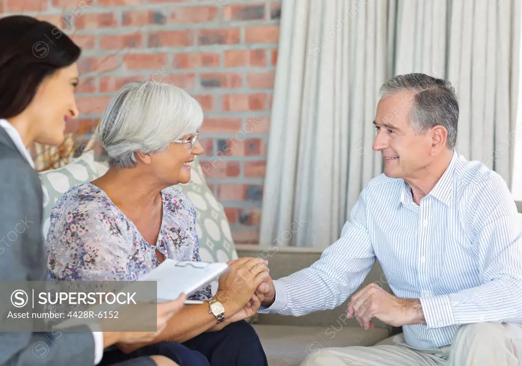 Financial advisor talking to couple on sofa