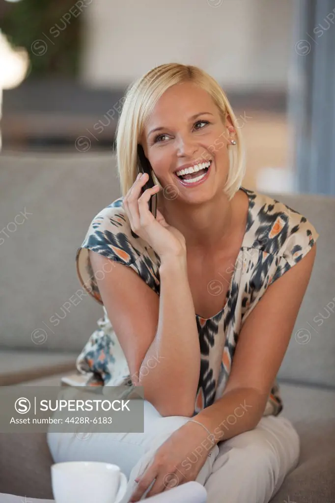 Woman talking on cell phone on sofa
