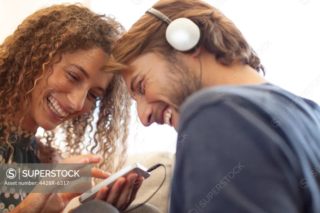 Smiling couple listening to headphones