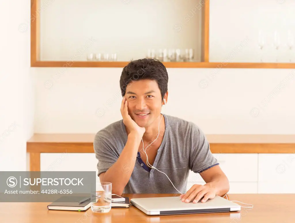 Man listening to headphones at table