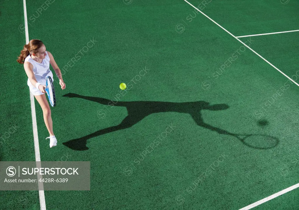 Tennis player casting shadow on court