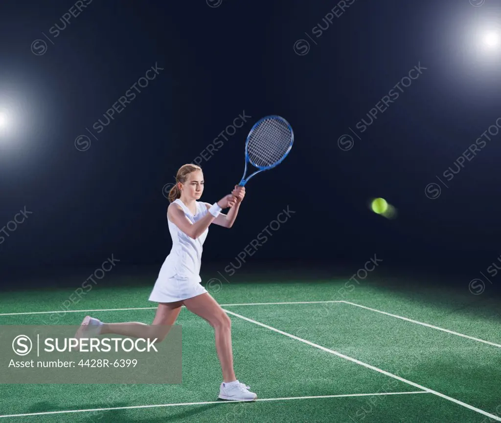 Tennis player hitting ball on court