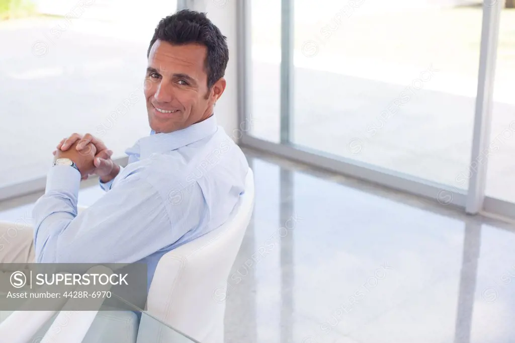 Businessman smiling in office chair