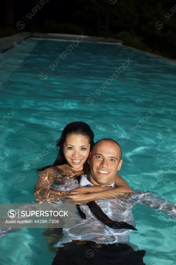 Fully dressed couple in swimming pool