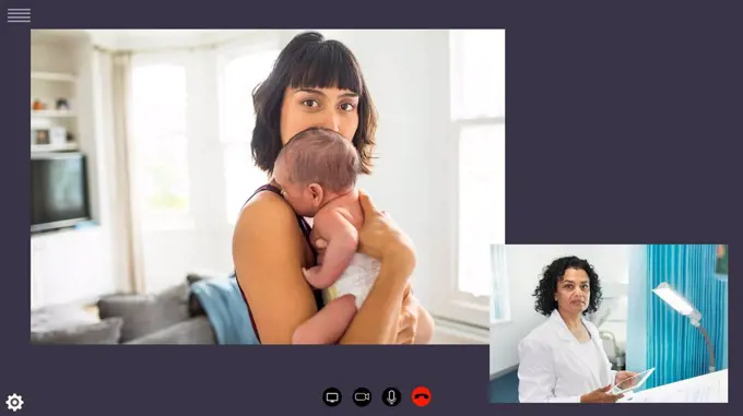 Mother with newborn baby video conferencing doctor during COVID-19