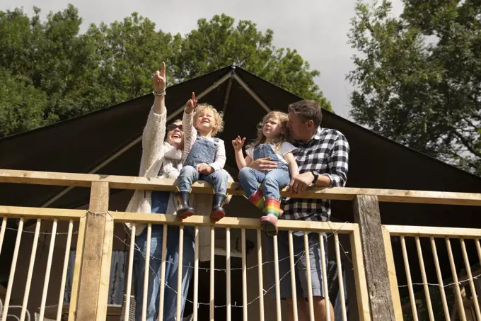 Happy family at sunny cabin railing