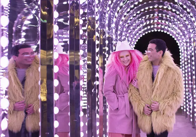 Happy fashionable couple walking under arch lights