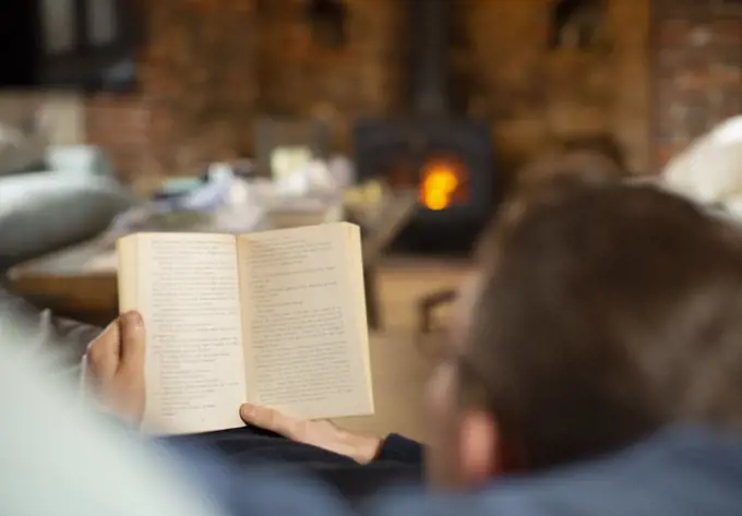 Man reading book in living room