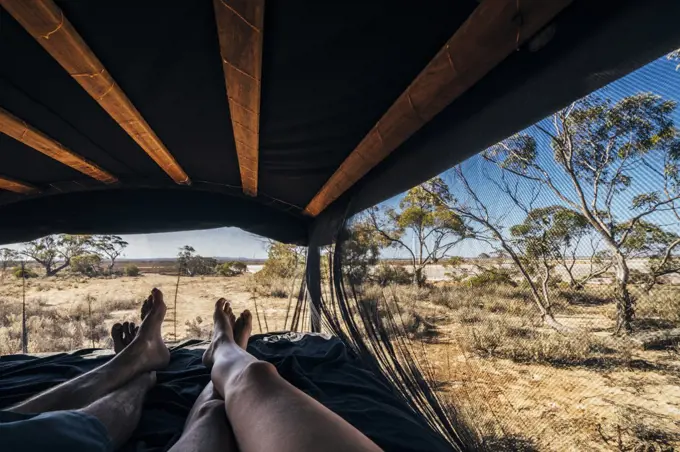 POV carefree couple relaxing in tent in remote landscape, Australia