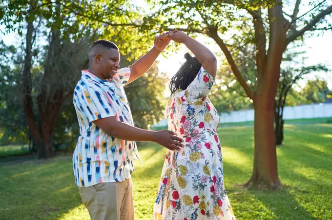 Happy couple dancing in summer backyard