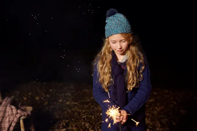 Girl playing with sparkler outdoors,belmonthouse, UK