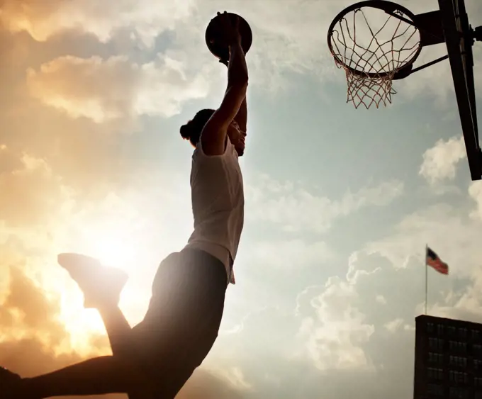 Man dunking basketball on court,New York