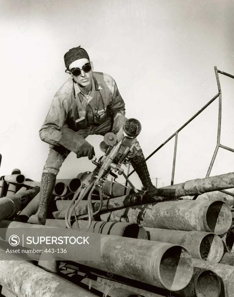 Pipefitter holding a machine, 1942