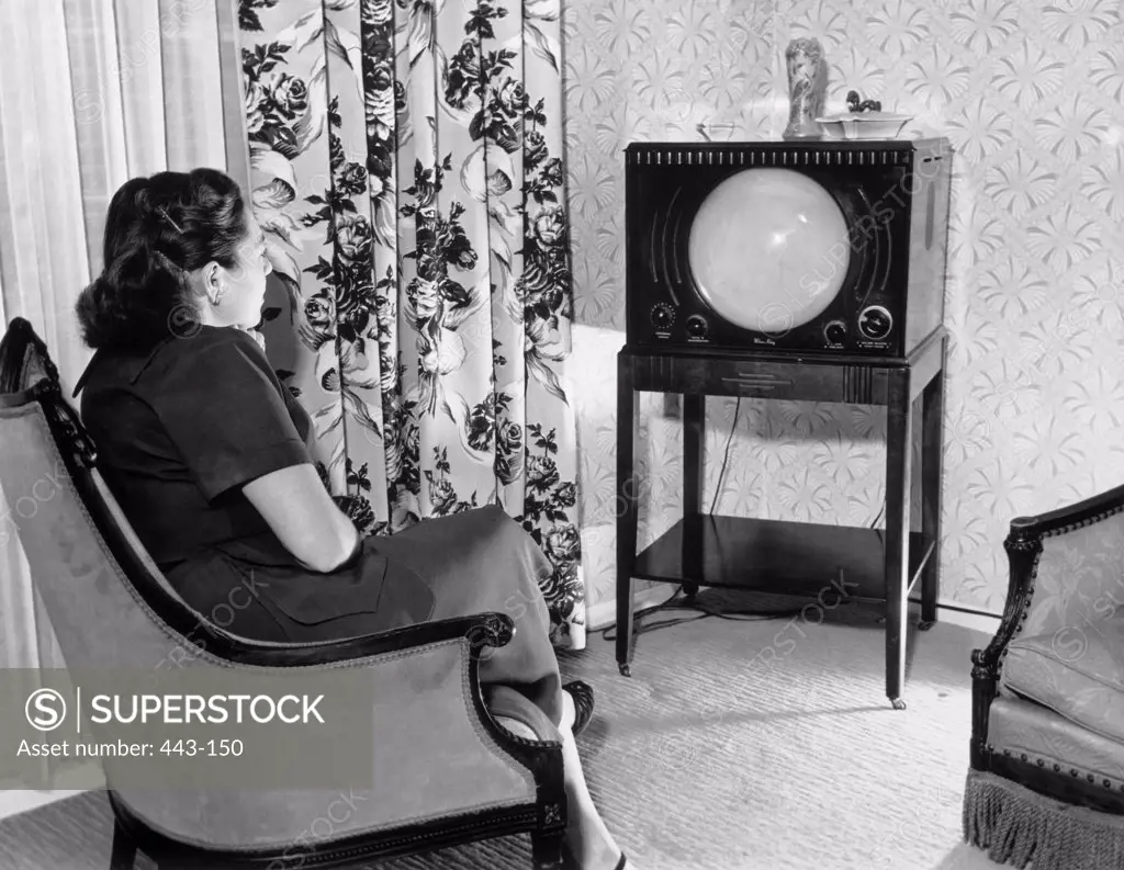Side profile of a mid adult woman watching television, 1952