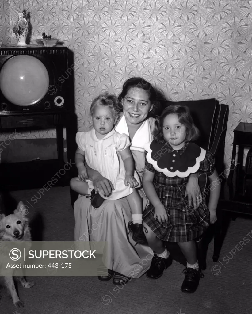 Portrait of a mother sitting with her two daughters, 1951