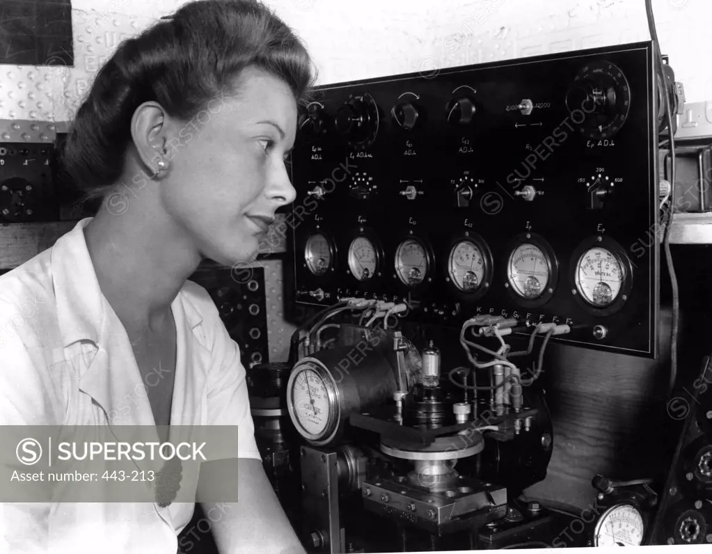 Side profile of a young woman monitoring gauges in a factory