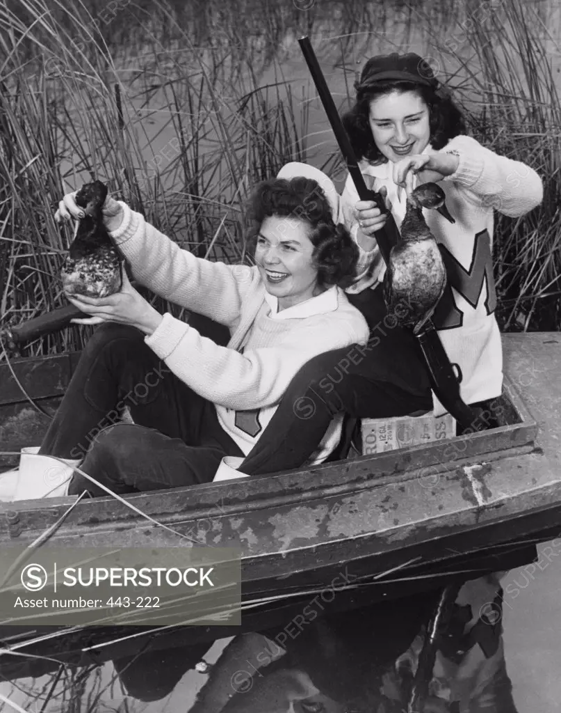 High angle view of two young women holding ducks, 1940