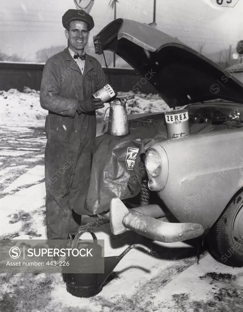 Portrait of a mid adult man repairing a car, 1940