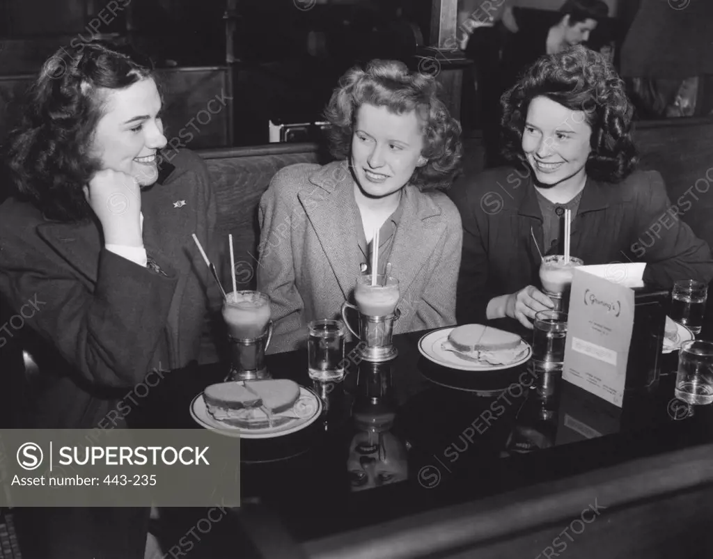 Mother sitting with her two daughters in a restaurant