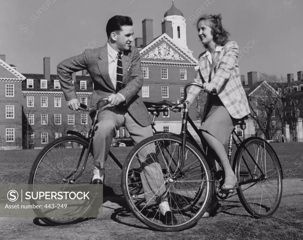 Young couple cycling on campus