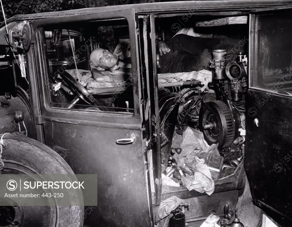 Senior man sleeping in an abandoned car, 1941