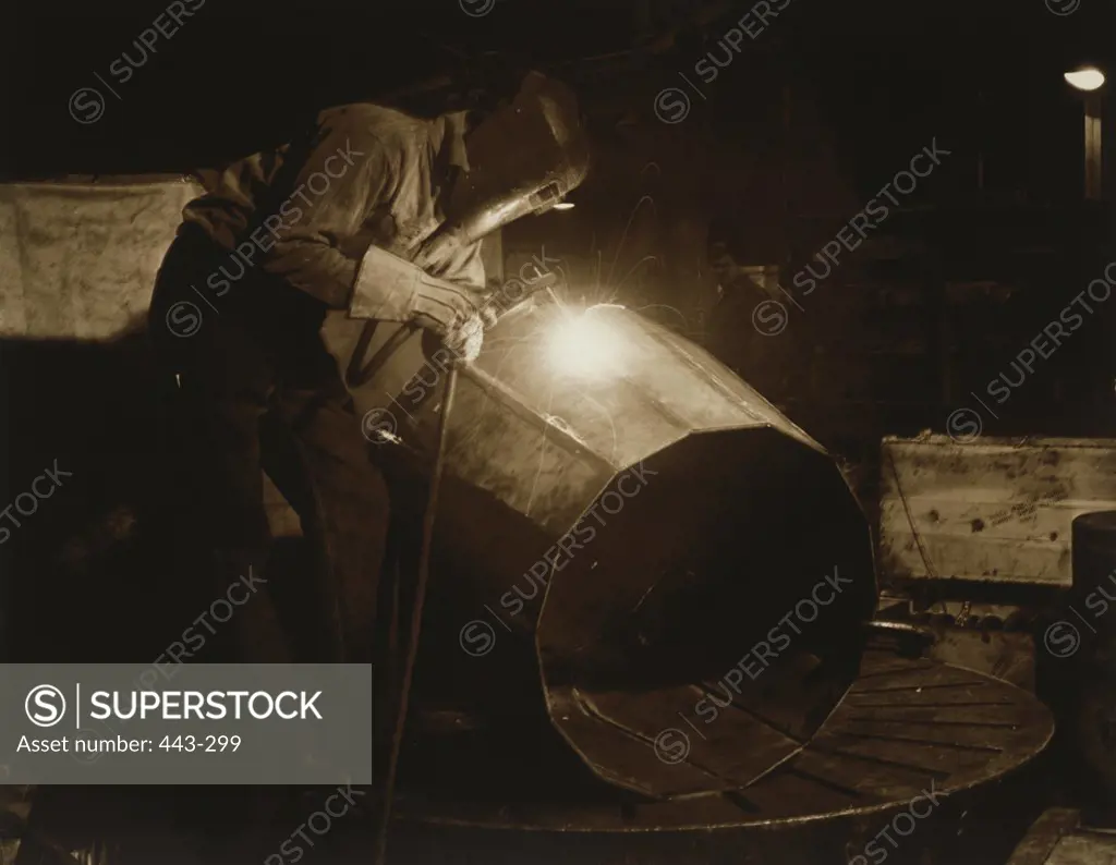 Side profile of a welder welding a container