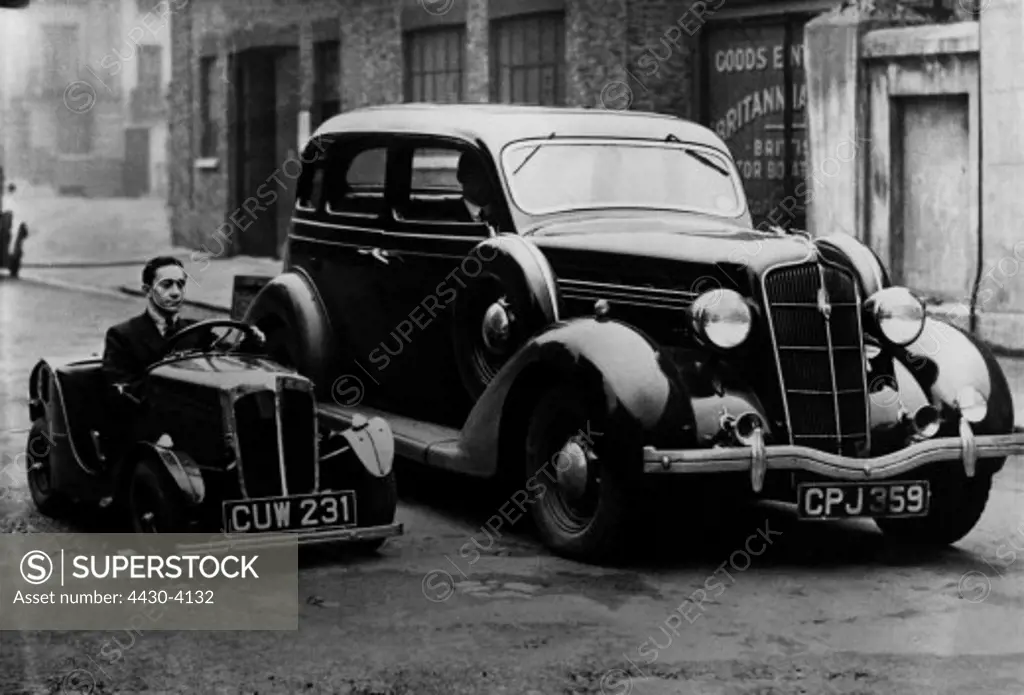 transport transportation car oddity small car beside a big limousine London Great Britain circa 1936,