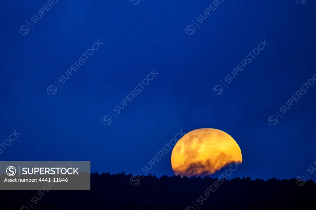A Supermoon (Super Moon) rising. A supermoon is the coincidence of a full moon or a new moon with the closest approach the Moon makes to the Earth on its elliptical orbit, resulting in the largest apparent size of the moon's disk.
