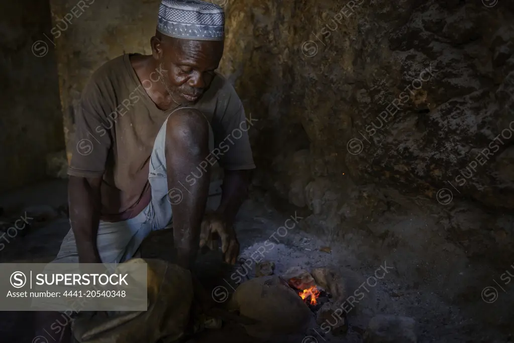 Silversmith using a hand bellows to melt silver. Ibo Island. Mozambique