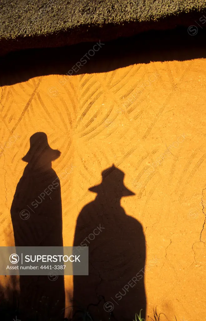 Basotho Men. Shadows on wall of hut. Bashotho Cultural Village. Quaqua. South Africa