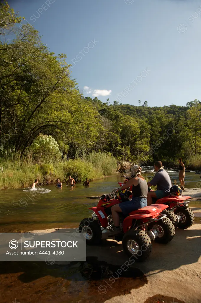 Tourists on quad biking trail swimming in Sabi River. Hazyview. Mpumalanga. South Africa