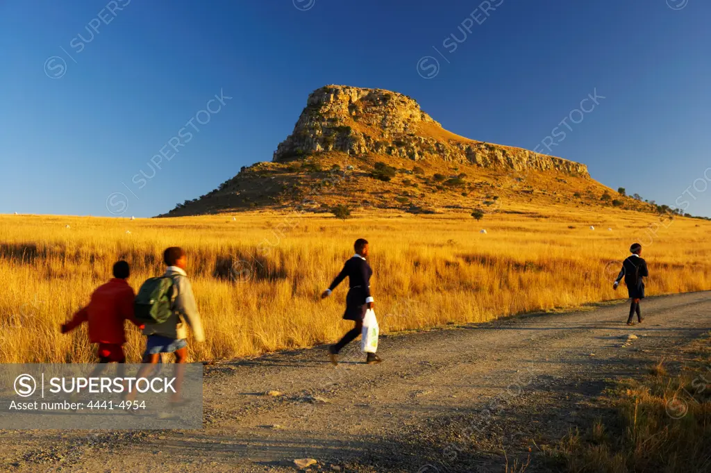 Children walk past the Battlefield of Isandlwana on their way to school. The Battle of Isandlwana occured during the Anglo Zulu War of 1879. Near Nqutu. kwaZulu-Natal. South Africa